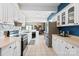 Well-lit kitchen with white cabinets, stainless steel appliances, and a functional layout at 447 Willow Pond Ln, Hiddenite, NC 28636