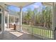 Covered patio with decorative brick columns and a view of the lush, wooded backyard, perfect for outdoor relaxation at 447 Willow Pond Ln, Hiddenite, NC 28636