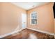 Cozy bedroom with hardwood floors, a double door closet, and a large window providing natural light at 4741 Eaves Ln, Charlotte, NC 28215