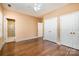 Spacious bedroom featuring hardwood floors, a ceiling fan, and two large closets for ample storage at 4741 Eaves Ln, Charlotte, NC 28215