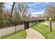 Winding sidewalk alongside a black metal fence, offers a private pathway for residents at 4743 Hedgemore Dr # E, Charlotte, NC 28209