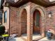 Arched brick entryway, a cozy porch with a wooden front door, and potted plants for charm at 6111 Gold Springs Way, Denver, NC 28037