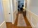 Open hallway with hardwood floors, wainscoting, and a view into the living area at 6111 Gold Springs Way, Denver, NC 28037