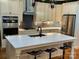 Kitchen island features bar stool seating and sink; stainless steel appliances and dark backsplash at 6111 Gold Springs Way, Denver, NC 28037