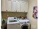 Bright laundry room with white cabinets and modern washer and dryer for convenient chores at 6111 Gold Springs Way, Denver, NC 28037