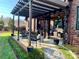 Covered patio features an outdoor dining set, a lounge area, and a garden path at 6111 Gold Springs Way, Denver, NC 28037