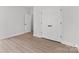 Minimalist bedroom with light wood-look flooring and closet/door offer a serene and inviting space at 615 W Stanly W St, Stanfield, NC 28163