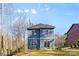 Rear view of a charming blue two-story home with a well-maintained lawn and lush surrounding trees at 615 W Stanly W St, Stanfield, NC 28163