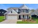 Charming two-story home with stone accents, vertical siding, covered porch, and attached two-car garage at 7024 Butternut Oak Ter, Huntersville, NC 28078