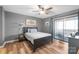 Cozy bedroom featuring a ceiling fan, balcony access, and wood-look flooring at 7360 Winery Ln, Charlotte, NC 28227