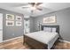 Gray bedroom with ceiling fan, neutral bedding, ensuite bath and wood floors at 7360 Winery Ln, Charlotte, NC 28227