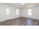 Bright, open living area featuring laminate flooring, two windows, and a door leading to the porch at 1018 Union St, Maiden, NC 28650