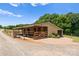 Equestrian barn featuring stalls with wood doors and a brick-paved approach, complemented by lush green landscaping at 1363 John Cline Ct, Lincolnton, NC 28092