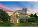 Rear exterior featuring a stone chimney, a large veranda, and a manicured lawn at 1363 John Cline Ct, Lincolnton, NC 28092