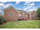 Backyard with a wood deck and brick exterior with green grass at 1730 Sanridge Wind Ln, Charlotte, NC 28262