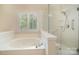 Bright bathroom with a jacuzzi tub and glass-enclosed shower at 1730 Sanridge Wind Ln, Charlotte, NC 28262