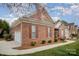 Side view of a well-maintained brick home with attached garage and manicured landscaping at 1730 Sanridge Wind Ln, Charlotte, NC 28262