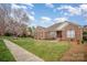 Charming brick home with manicured lawn and tidy landscaping under a partly cloudy blue sky at 1730 Sanridge Wind Ln, Charlotte, NC 28262