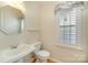 Cozy half bathroom with a pedestal sink and a window with a patterned valance at 1730 Sanridge Wind Ln, Charlotte, NC 28262