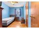 Bright bedroom featuring blue walls, wood floors, and functional furniture at 1802 Young Dr, Conover, NC 28613