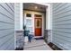 Cozy front porch with a charming red door, stone accents, and a comfortable chair at 212 Laura Elizabeth Ln, Clover, SC 29710