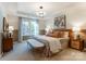 Serene main bedroom featuring a tray ceiling, a decorative chandelier, and natural light at 212 Laura Elizabeth Ln, Clover, SC 29710