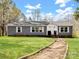 Charming single-story home featuring a landscaped yard, inviting pathway, and classic architectural details at 33 Travora Cir, York, SC 29745