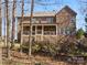 Back exterior view of brick home with a covered deck and stairs leading to the yard at 604 Wisteria Walk Way, Fort Mill, SC 29715