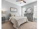 Inviting bedroom with a patterned duvet, dresser, and bedside table under natural light at 604 Wisteria Walk Way, Fort Mill, SC 29715