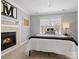 Comfortable bedroom with fireplace, window, neutral color palette and minimalist design at 604 Wisteria Walk Way, Fort Mill, SC 29715