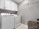 Functional laundry room with white washer and dryer units, wire rack shelving, and tiled flooring at 604 Wisteria Walk Way, Fort Mill, SC 29715