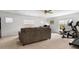 Open living room with a comfortable sofa, large windows, and an adjacent exercise area at 604 Wisteria Walk Way, Fort Mill, SC 29715