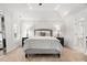 Light-filled main bedroom featuring a tray ceiling, bedside tables, plush carpet, and lots of light from the window at 604 Wisteria Walk Way, Fort Mill, SC 29715