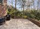 Spacious brick patio for outdoor cooking with a blackstone grill and manicured bushes at 604 Wisteria Walk Way, Fort Mill, SC 29715