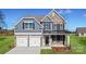 Beautiful two-story home with stone and siding exterior, featuring a two-car garage and well-manicured lawn at 7020 Butternut Oak Ter, Huntersville, NC 28214