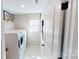 Modern laundry room featuring a washer and dryer, storage shelves, and natural light at 7020 Butternut Oak Ter, Huntersville, NC 28214