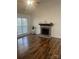 Bright living room with wood flooring, fireplace, and a large window for natural light at 7144 Hunters Bluff Dr, Denver, NC 28037