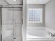 Bathroom featuring a glass-enclosed shower and a separate soaking tub with a tiled window at 737 Sanside Dr, York, SC 29745