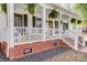 Close up front porch view highlighting the seating area, plants, and brick foundation at 737 Sanside Dr, York, SC 29745