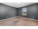 Cozy bedroom featuring neutral walls and carpeted floors; natural light from window at 887 Pointe Andrews Dr, Concord, NC 28025