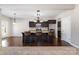 Open kitchen with granite island, dark wood cabinetry, and view into the adjacent living spaces at 887 Pointe Andrews Dr, Concord, NC 28025