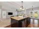 Open kitchen featuring an island with granite countertop, dark cabinets, and stainless steel dishwasher at 887 Pointe Andrews Dr, Concord, NC 28025