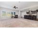 Open-concept living room featuring large windows, neutral carpet, and flows into the kitchen at 887 Pointe Andrews Dr, Concord, NC 28025