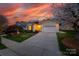 Beautiful sunset view of a home with a manicured lawn, flowering trees, and a two-car garage at 974 Platinum Dr, Fort Mill, SC 29708