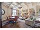 A cozy living room showcasing a coffered ceiling, built-in bookshelves, and comfortable leather seating at 974 Platinum Dr, Fort Mill, SC 29708