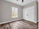 Neutral bedroom features wood-look floors, a window, ceiling fan, and double doors for closet space at 1313 Gidney St, Shelby, NC 28150