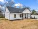 Attractive exterior of a white home with a covered porch and contrasted by a dark roof and black columns at 1313 Gidney St, Shelby, NC 28150