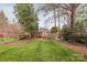 Well-maintained backyard featuring a wooden deck and mature trees at 2508 Bay St, Charlotte, NC 28205