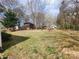 Large backyard with open shed, swing and wooden playhouse surrounded by mature trees at 316 Reese St, Gastonia, NC 28056