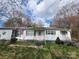 Charming one-story home with white siding, green shutters, an American flag, and a well-manicured front lawn at 316 Reese St, Gastonia, NC 28056